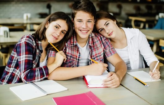 cheerful-students-posing-table